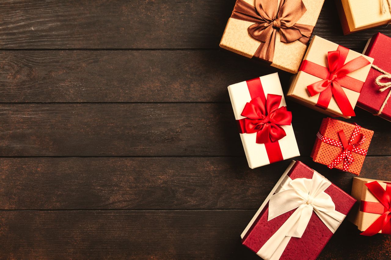 Beautifully wrapped holiday gifts with ribbons on a wooden surface, perfect for Christmas celebrations.